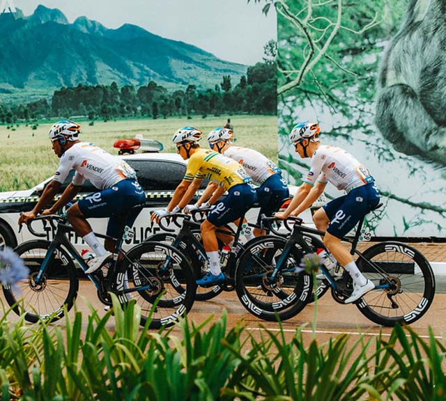 Bicyclists race down a roadway.